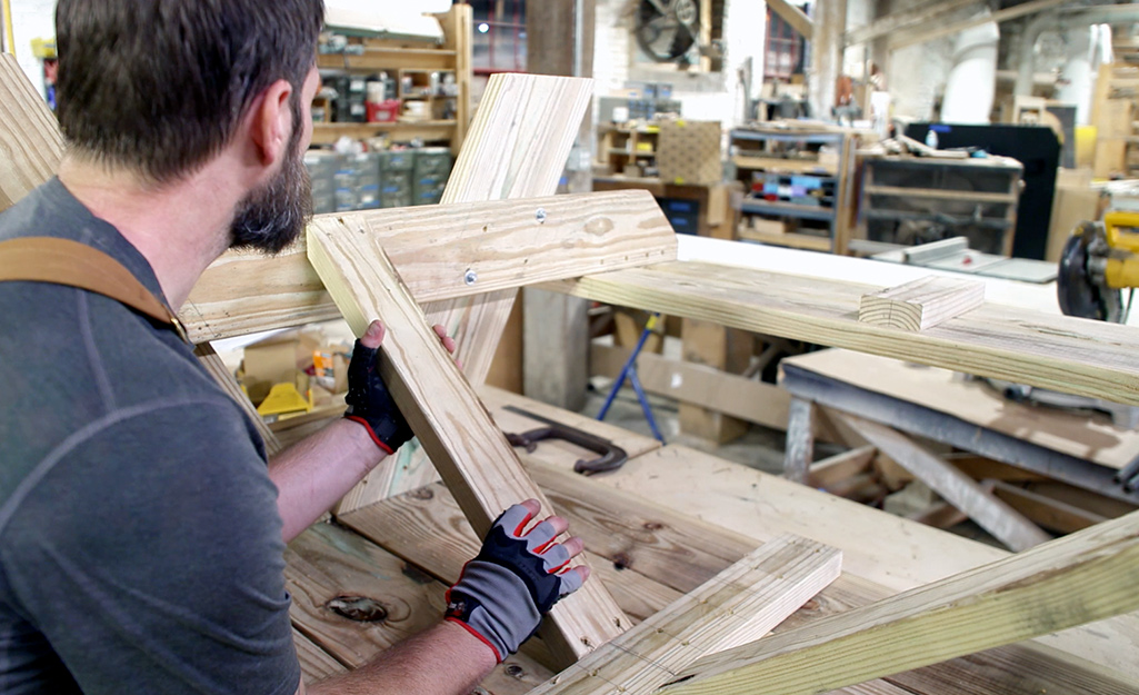 Someone adding support braces to a picnic table.