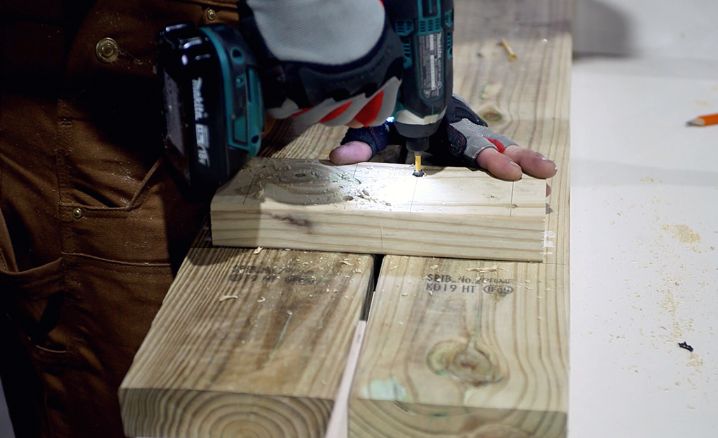 Someone building benches for a picnic table.