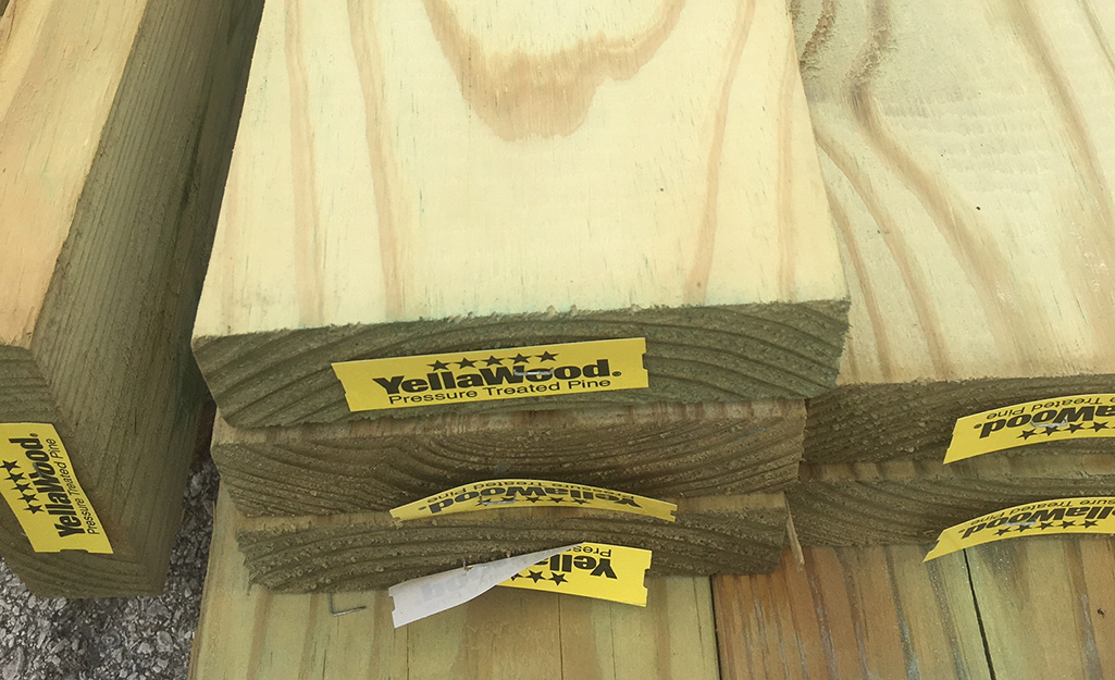 Pressure-treated boards stacked in a pile. Pressure-treated boards stacked in a pile.