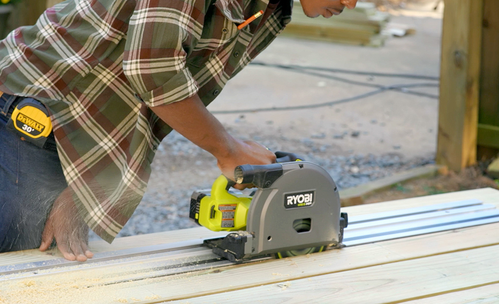 Cutting a hole for a cooler in the top of a picnic table, using a battery powered track saw.