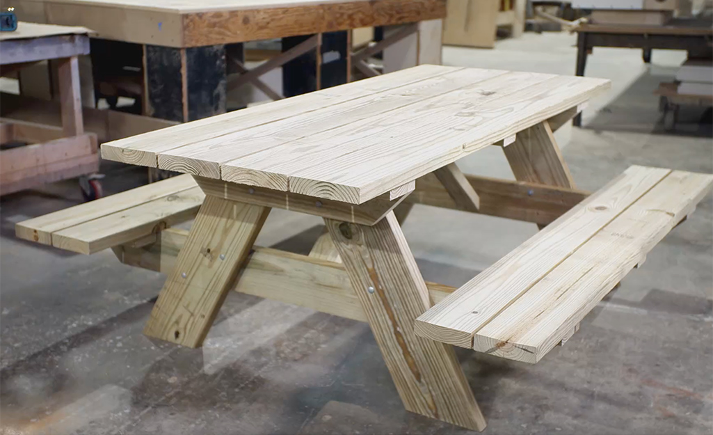 A newly built picnic table stands in a wood shop. 