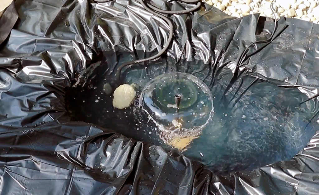 A pond kit creates a small fountain of water in the center of a pond.