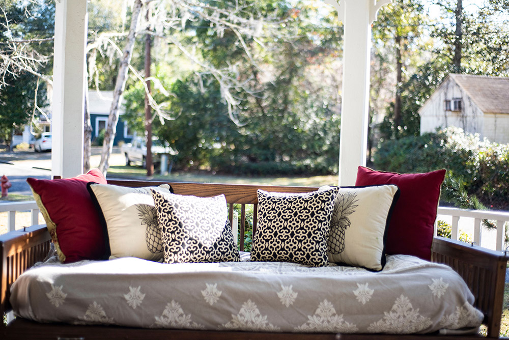 A front porch swing with decorative pillows
