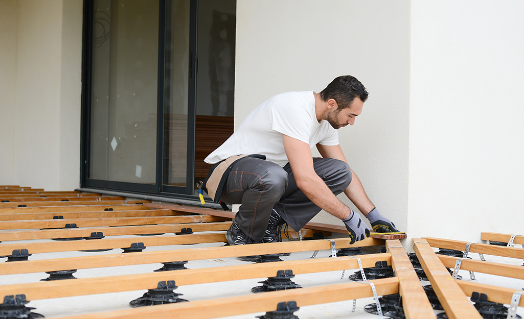 A man lays out the footings for a raised deck. A man lays out the footings for a raised deck.