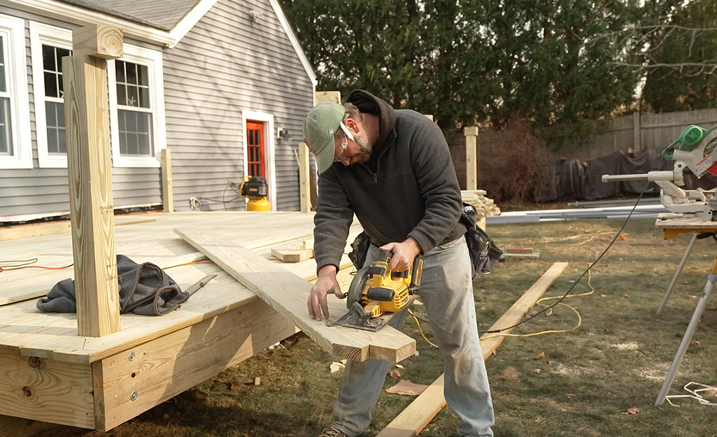 A person cutting lumber for stairs.
