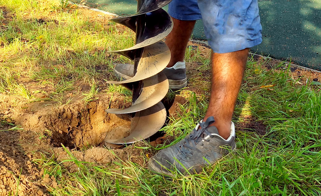 A man digs holes in a backyard. A man digs holes in a backyard.
