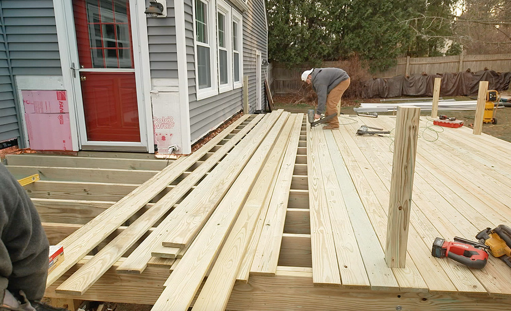 A person installing decking boards.