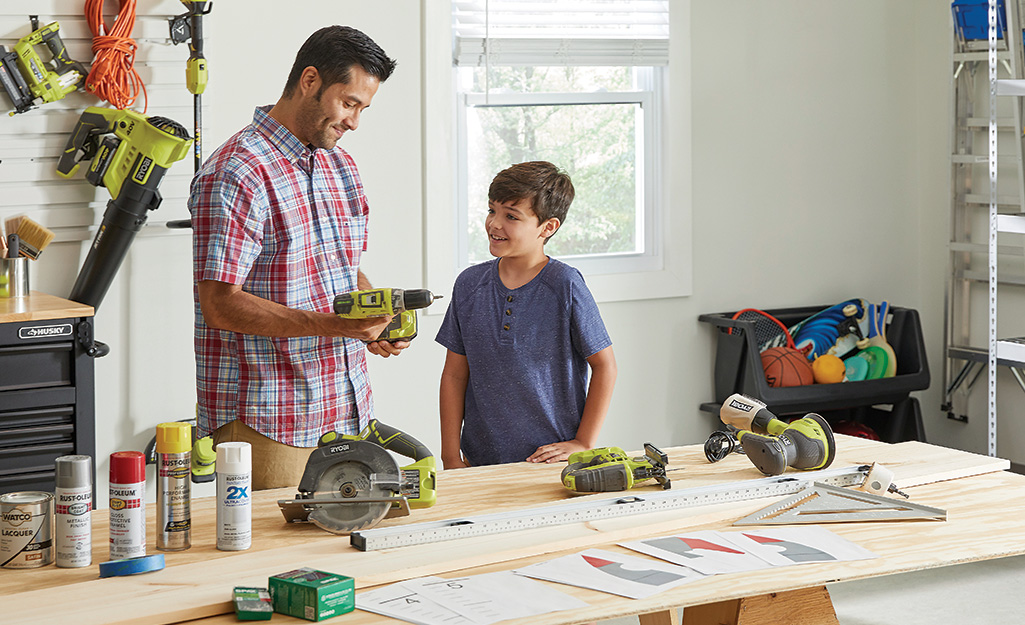 A father and child look over the tools and materials to build a growth chart project. A father and child look over the tools and materials to build a growth chart project.