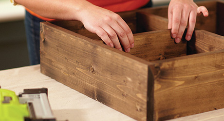 Someone adding a divider shelf to the inside of the serving station.