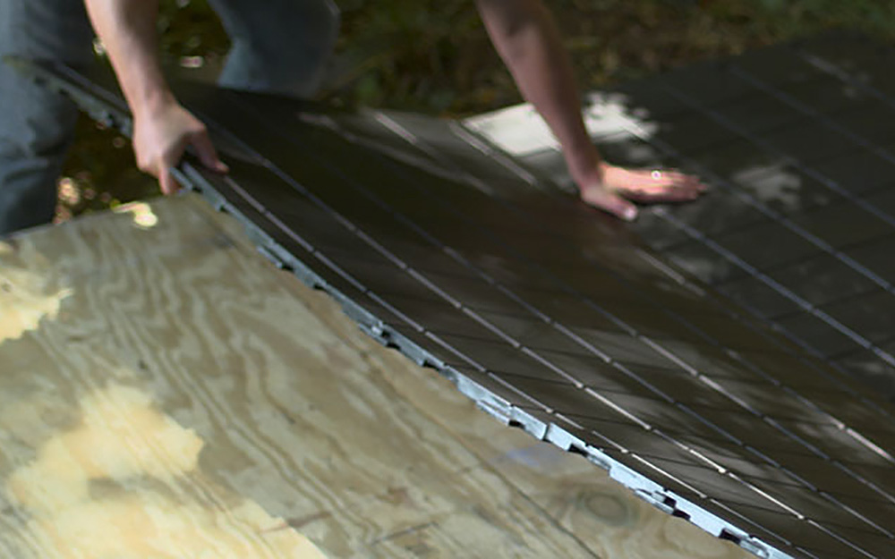 A man assembles the floor of a DIY shed. A man assembles the floor of a DIY shed.