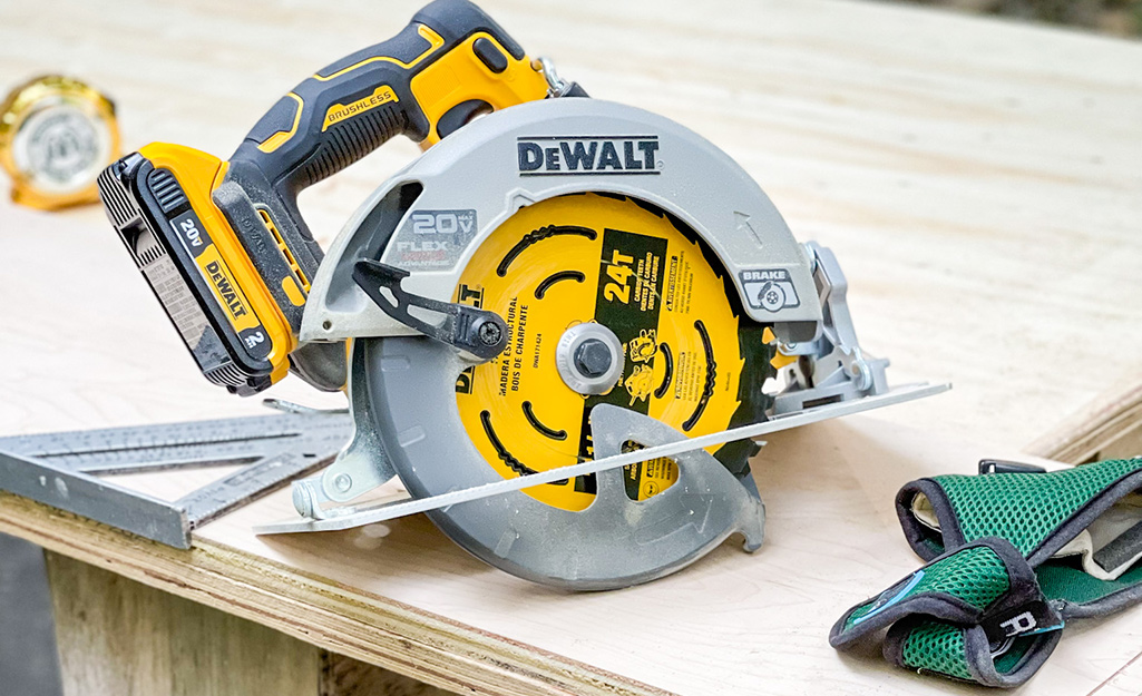 A circular saw lays on a wooden worktable.