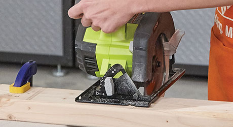 Person cutting lumber using a circular saw Person cutting lumber using a circular saw
