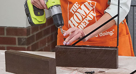 Person using drill to attach back bracket Person using drill to attach back bracket