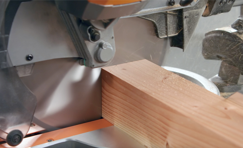 A woman uses a circular saw to cut the lumber.
