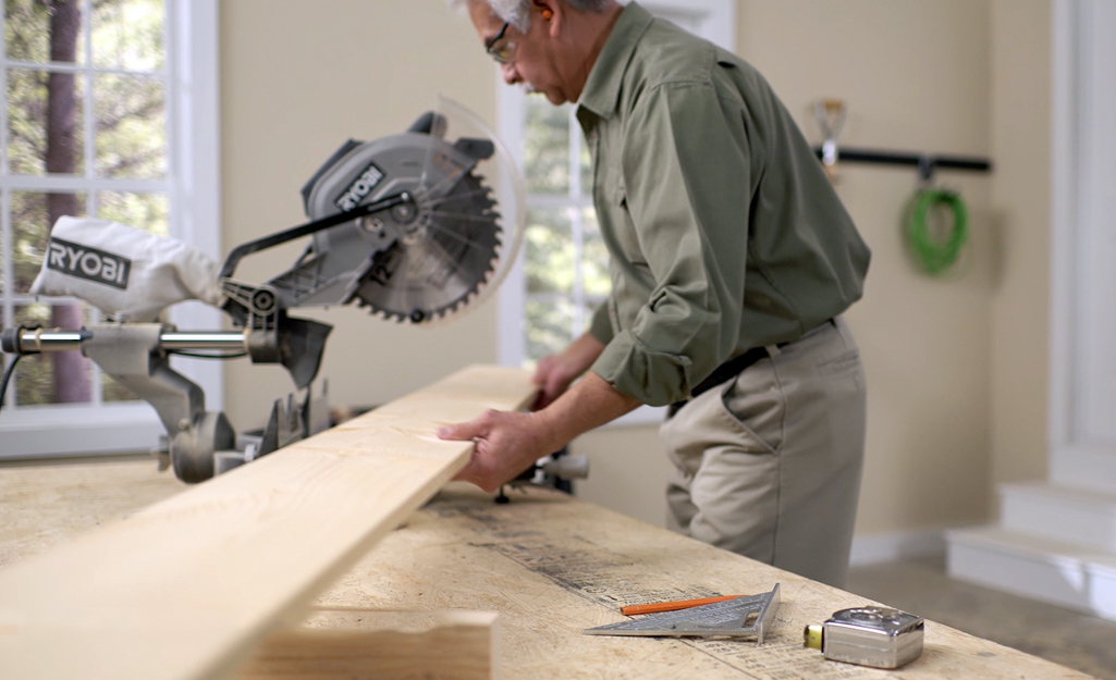 A man places down the wood plank.