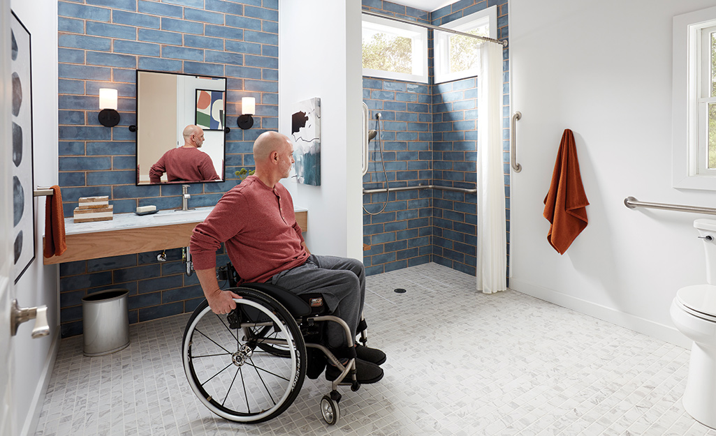 A man turns his wheelchair in a bathroom.