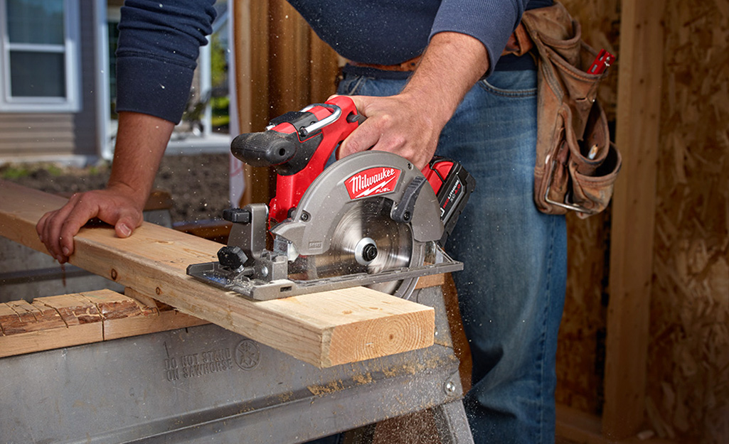 Woodworker holds saw in workshop