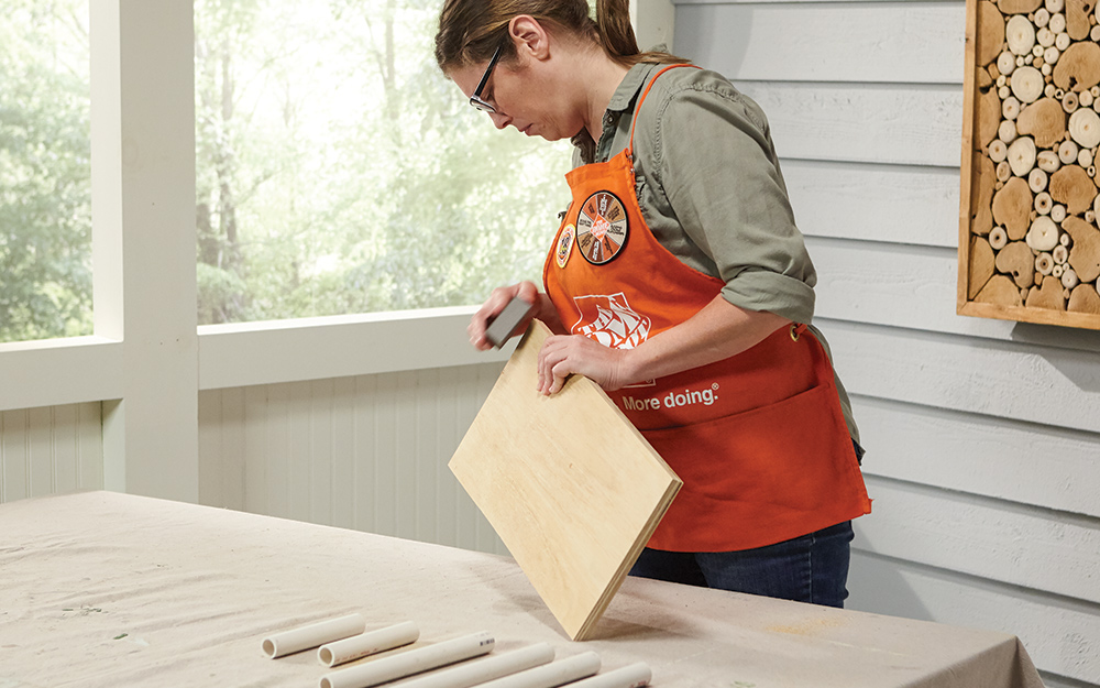 A Home Depot Associate sands the edges of a plywood board for a DIY crate table. A Home Depot Associate sands the edges of a plywood board for a DIY crate table.