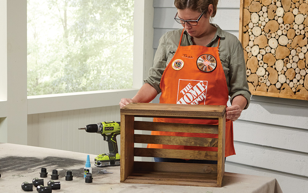 A Home Depot Associate attached bottom board to wood crate using wood screws. A Home Depot Associate attached bottom board to wood crate using wood screws.