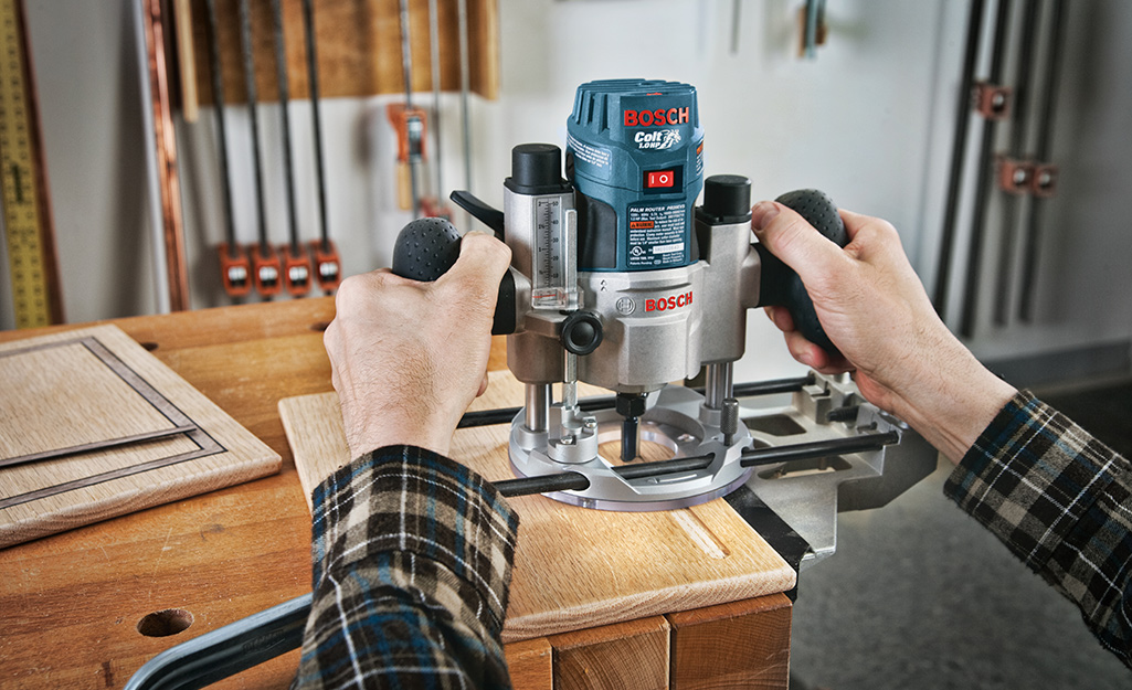 A person using a router to cut plywood for utility shelves. A person using a router to cut plywood for utility shelves.