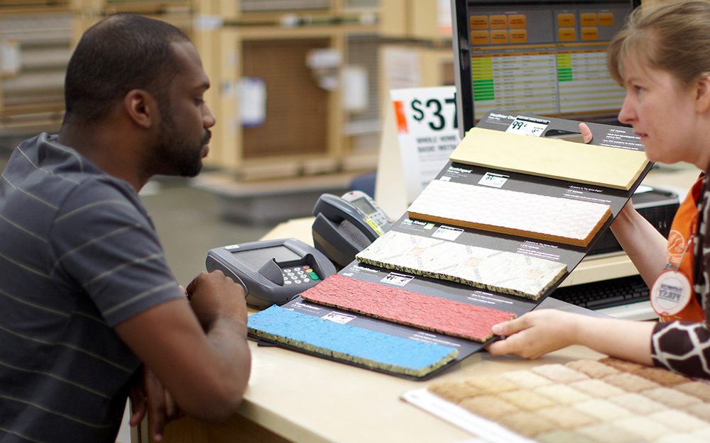 A customer examining different types of carpet padding.