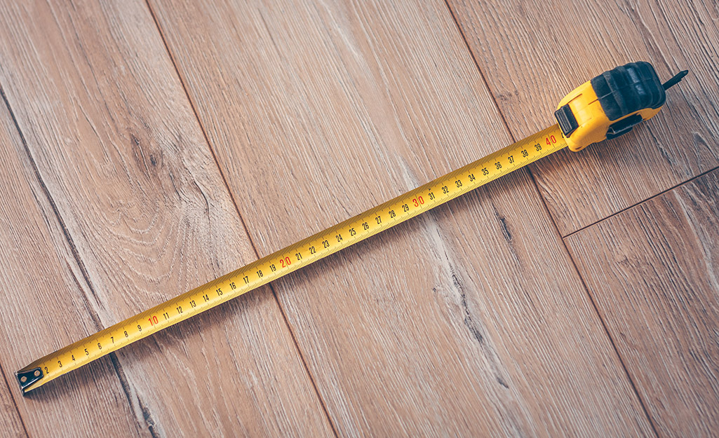An extended measuring tape placed on a wood floor.