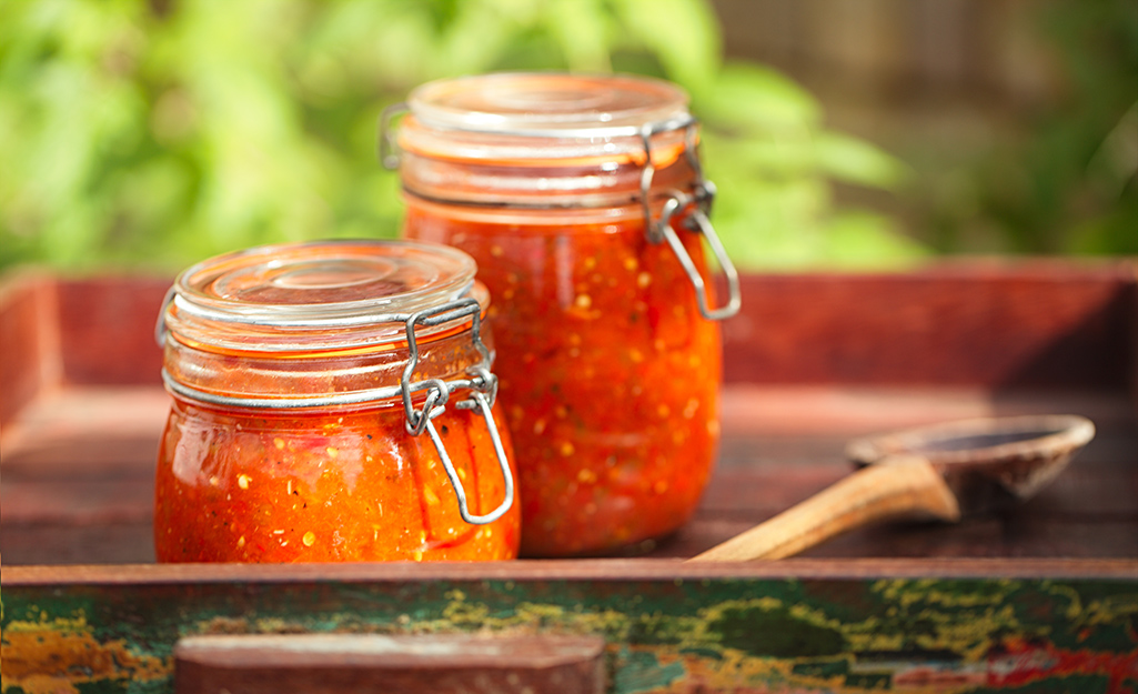 Two jars of canned salsa on a serving tray. Two jars of canned salsa on a serving tray.
