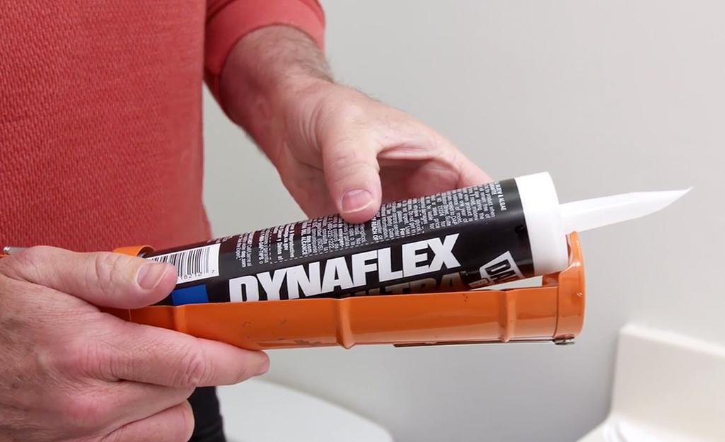 A person loading a caulk cartridge into caulk gun. A person loading a caulk cartridge into caulk gun.