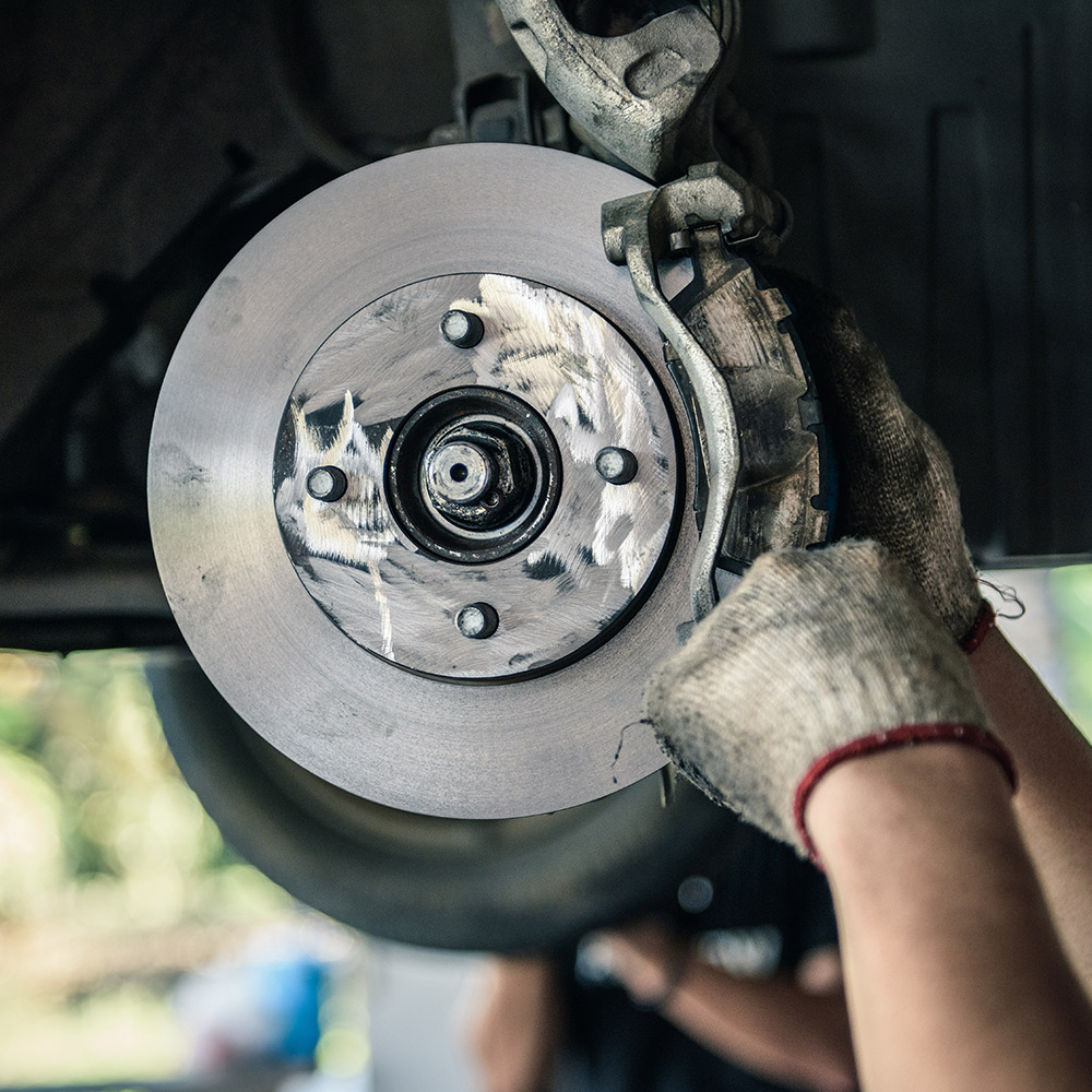 A person removing brake pads from a vehicle.