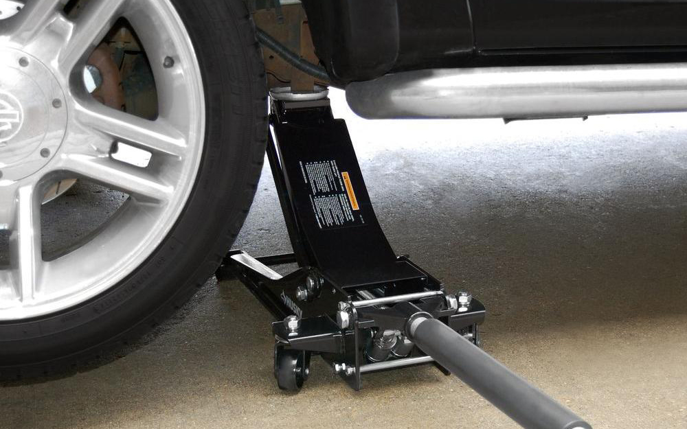 An auto jack begins to lift a vehicle.