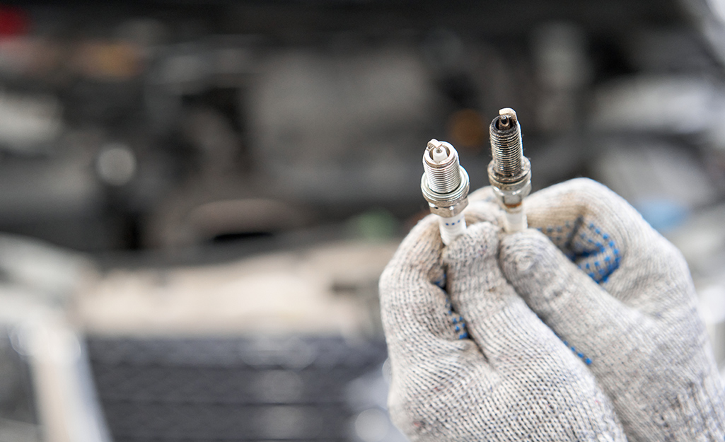 A person holding spark plugs. 