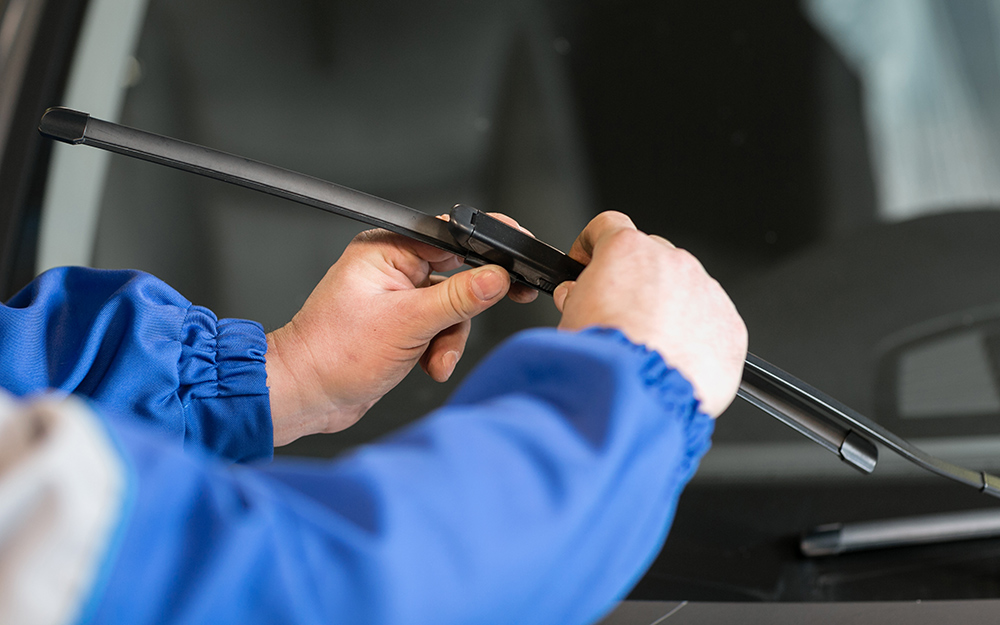 A person attaches a new windshield wiper blade to the blade hook.