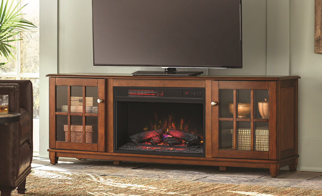 A large wood fireplace TV stand sits next to a window.