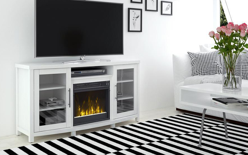 A modern white fireplace TV stand with doors in a living room with striped rug.