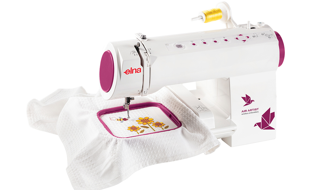 An embroidery sewing machine stitching decorative flowers onto fabric