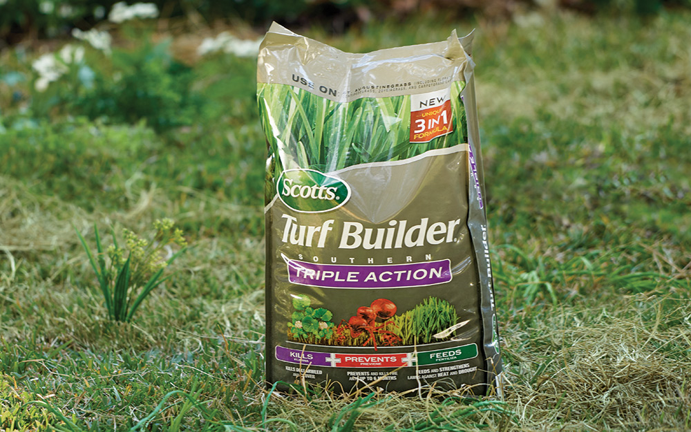 Bag of a multi-benefit fertilizer sitting on a lawn.