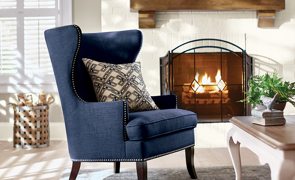 A lit fireplace with a fireplace screen in a home's living room.