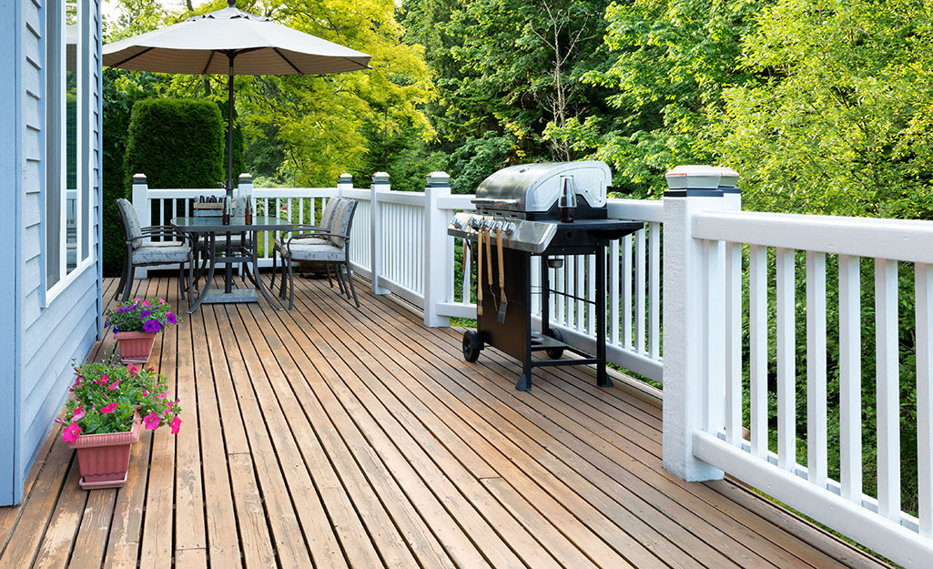 A stained deck surrounded by white railing.