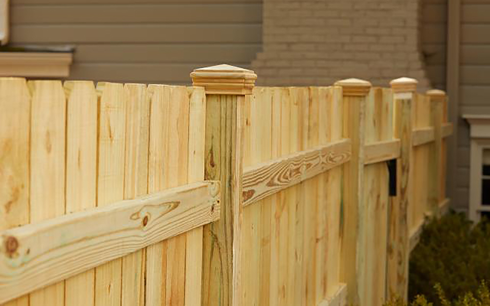 A new fence stands outside of a home.