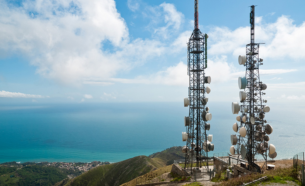 A pair of television transmitter towers stand on a hill.