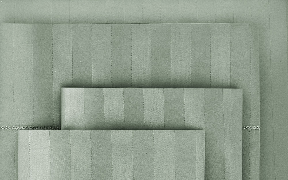 A close-up shot of green striped sheets in a soft cotton. 