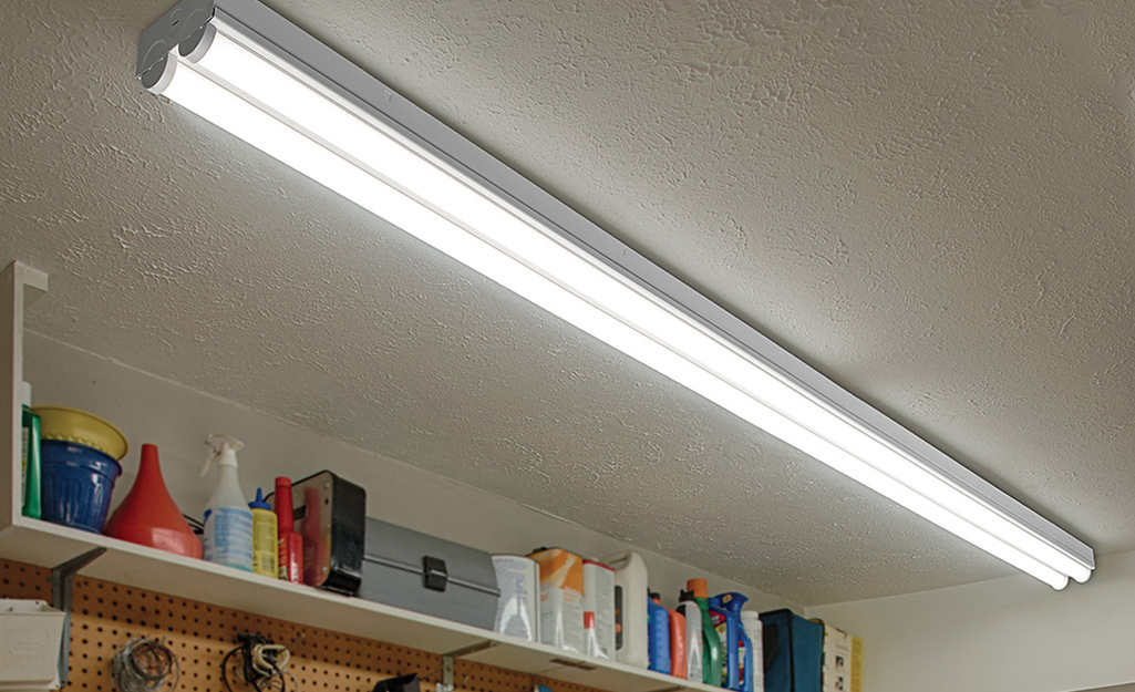 A pair of fluorescent strip lights installed in a garage.