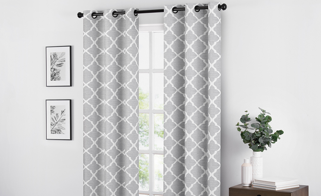 Grey and white patterned curtains hang in a living room.