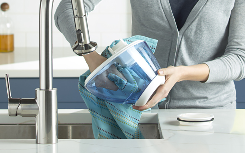 A person drying the top of a humidifier.