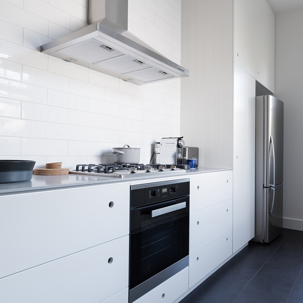 A cooking range hood above a stove in a kitchen.