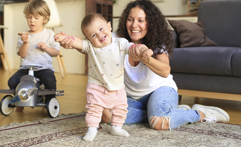 A family sitting on an area rug.