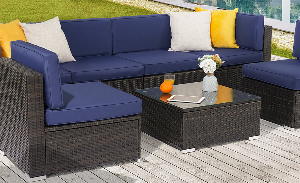 An outdoor sofa with clean cushions on a patio.