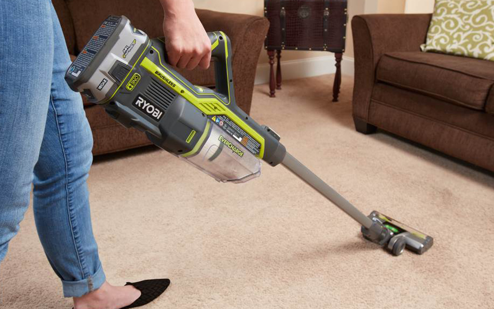 Woman vacuuming carpet before steam cleaning it. 