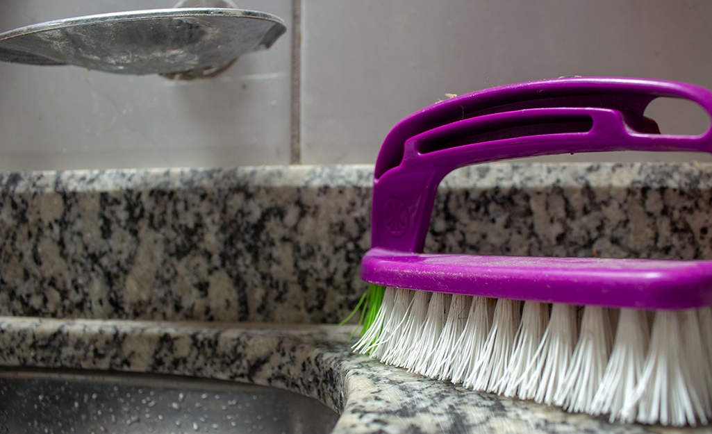 Scrub brush sitting on a granite countertop.