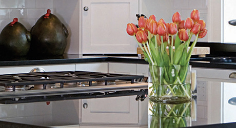 A vase of red tulips sitting on top of a clean kitchen countertop. A vase of red tulips sitting on top of a clean kitchen countertop.